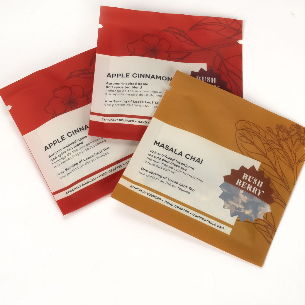 Three tea bags with labels for Apple Cinnamon, Masala Chai, and Bush Berry on a white background.