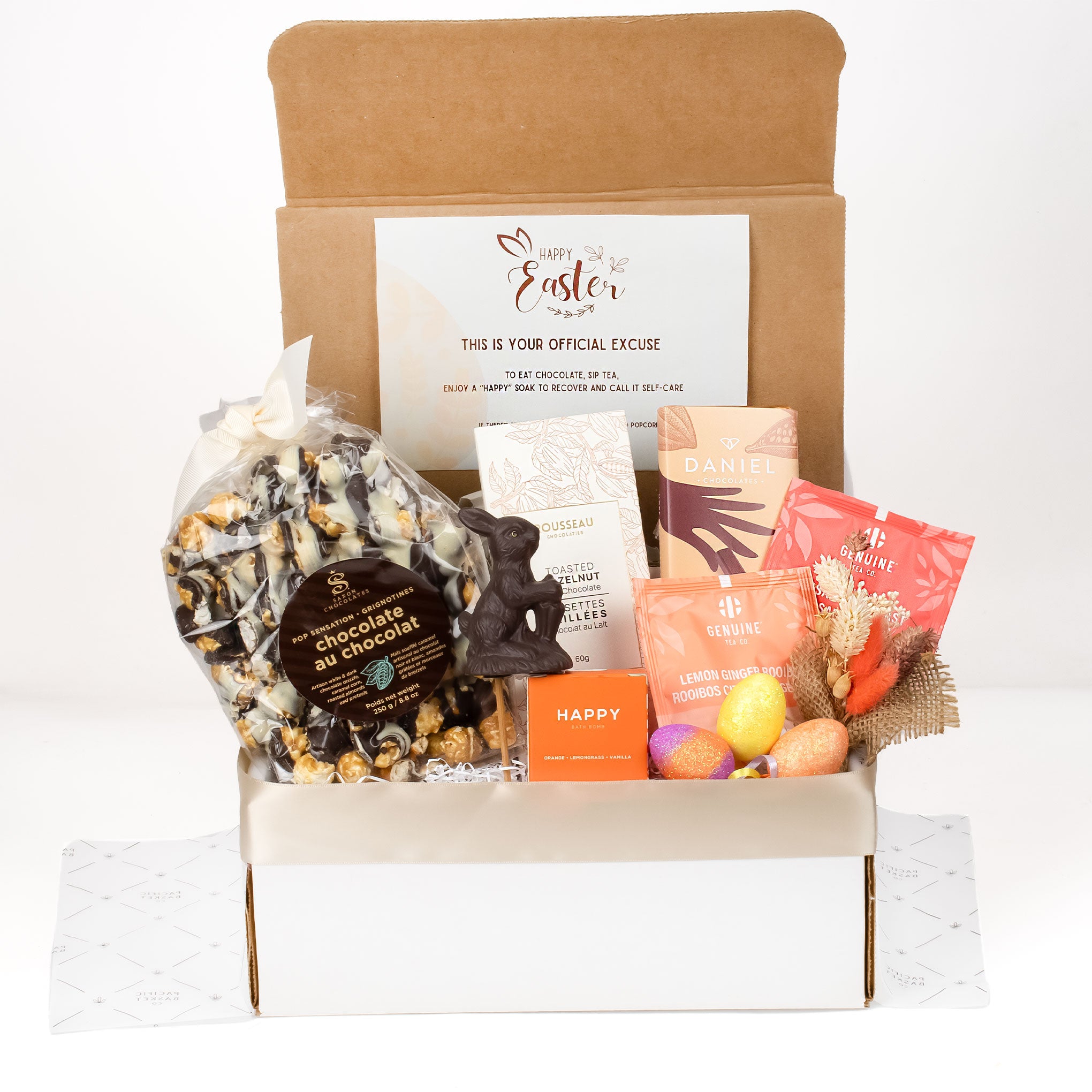 Gift box with Easter-themed items including a chocolate bunny and candy on a white background