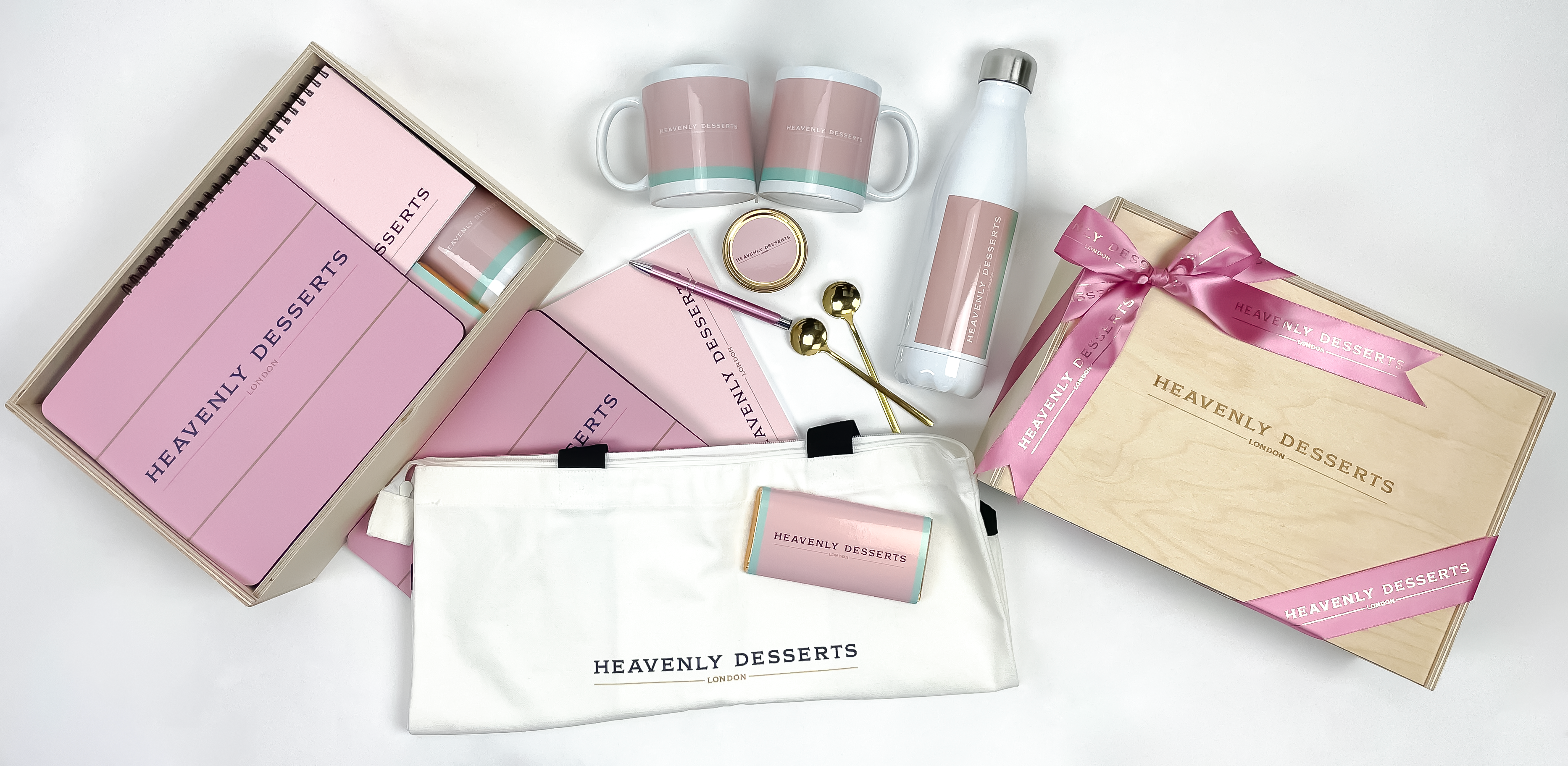 Collection of 'Heavenly Desserts' branded items including mugs, a water bottle, and a box on a white background.