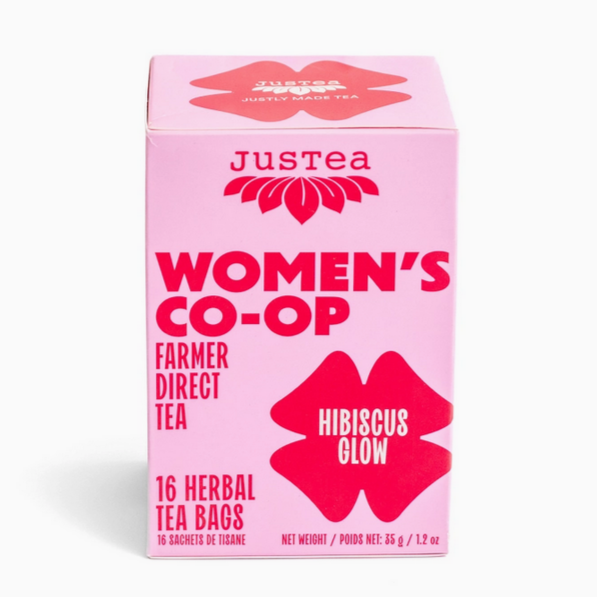 Pink box of Justea Women's Co-op Farmer Direct Tea with hibiscus flavor on a white background