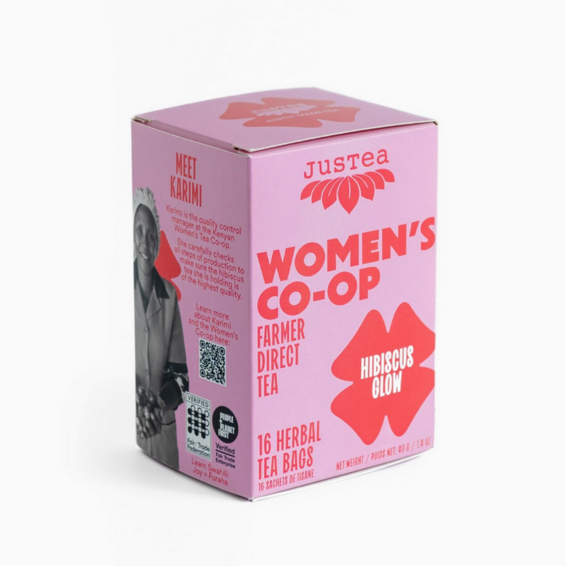 Pink box of Justea Women's Co-op Hibiscus Glow tea on a white background