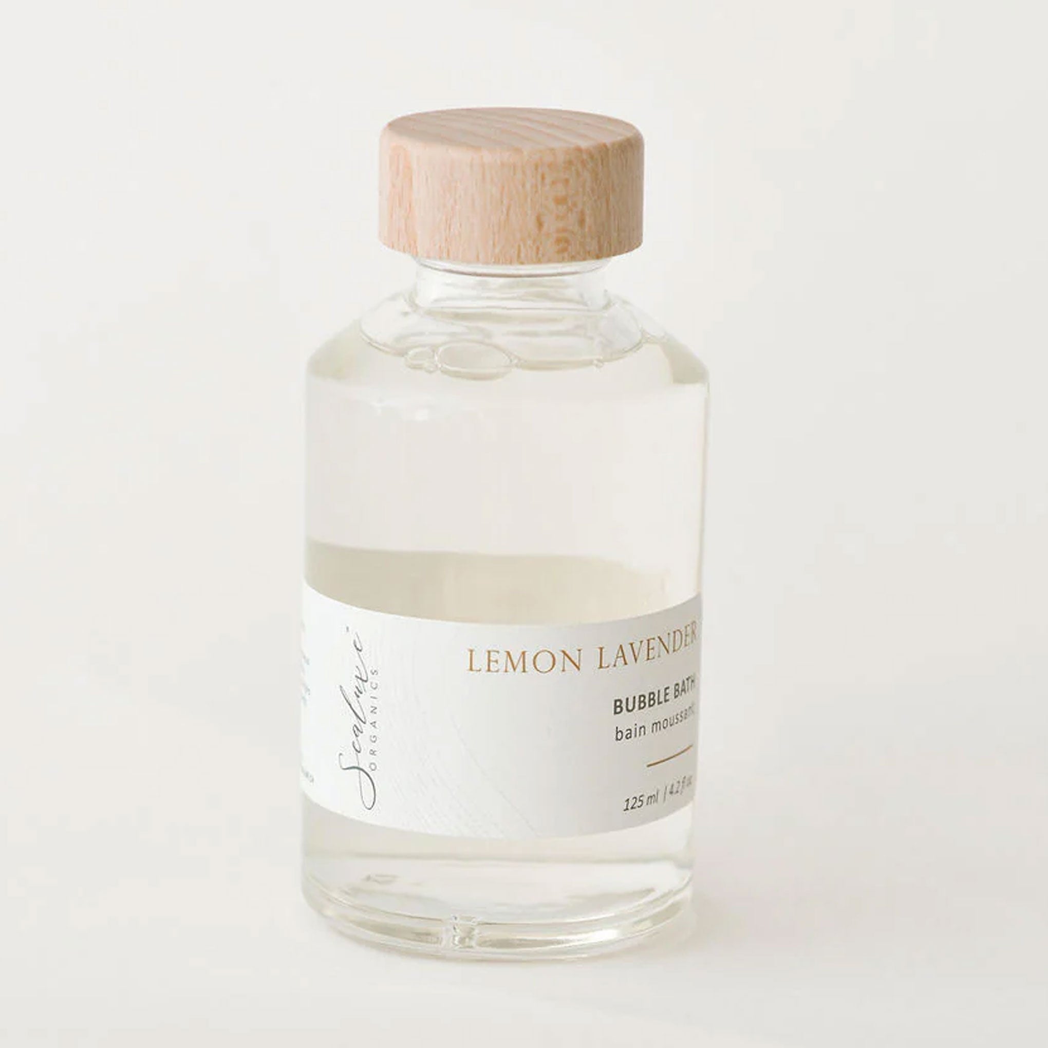 Bottle of lemon lavender bubble bath with a wooden cap on a white background