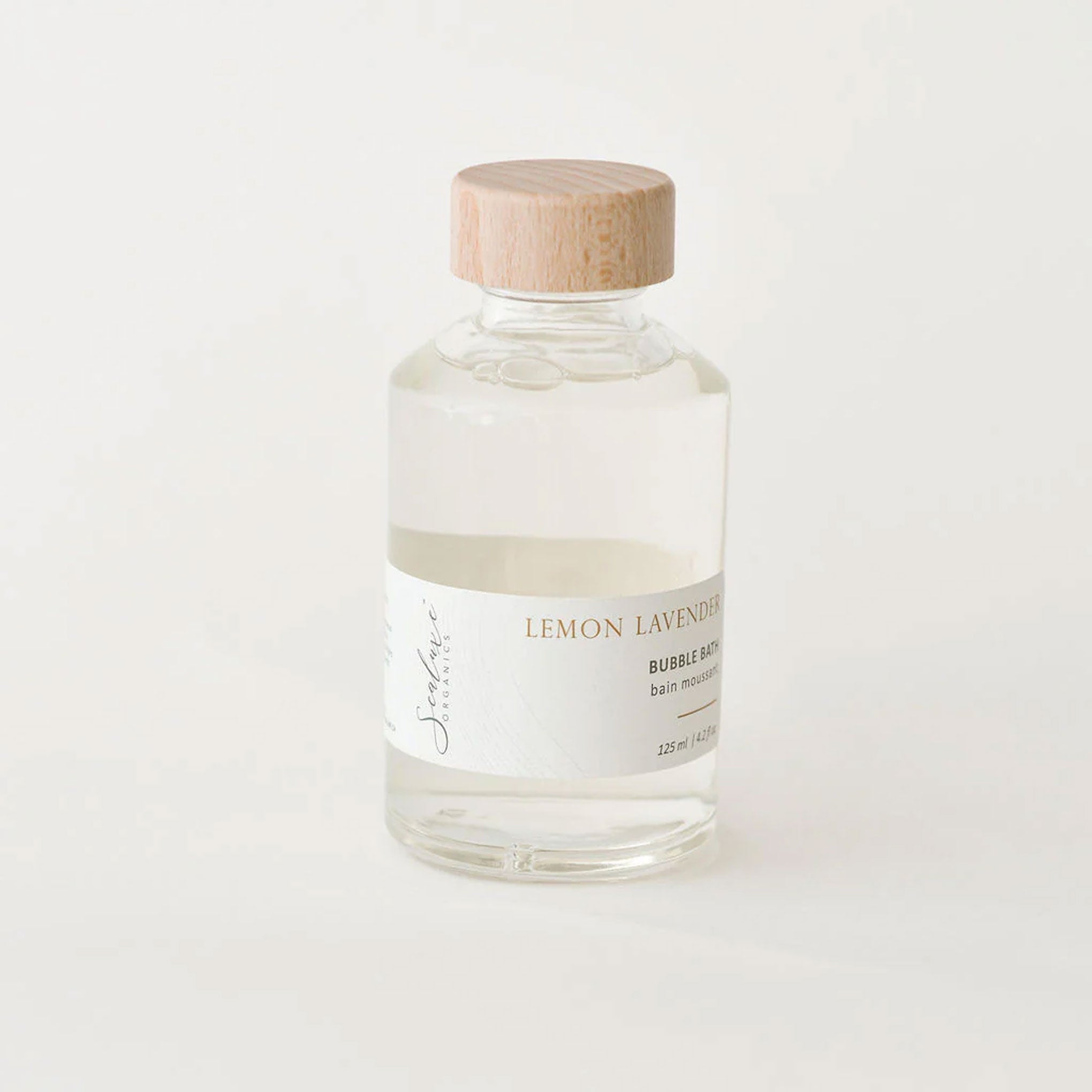 Bottle of Sealuxe lemon lavender bubble bath with wooden cap on a white background