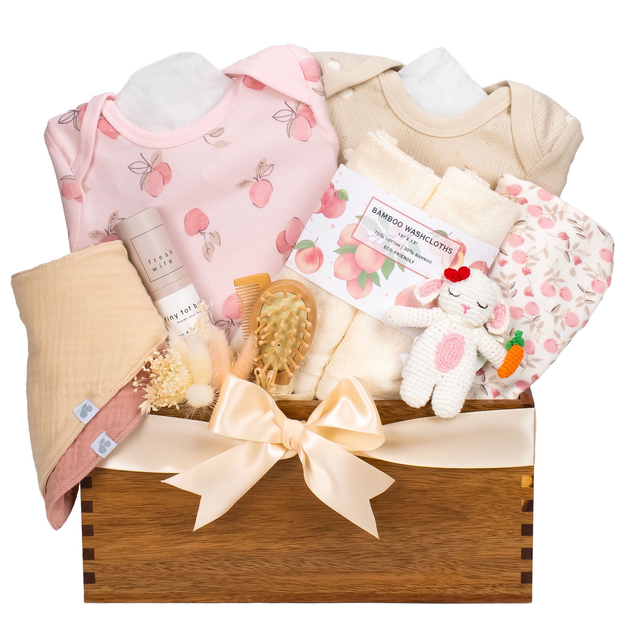 Handcrafted wooden baby gift basket called Sweet Orchard featuring apple and peach print onesies, bamboo washcloths, and a crochet bunny on a white background.