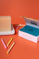 Candle and packaging on an orange background