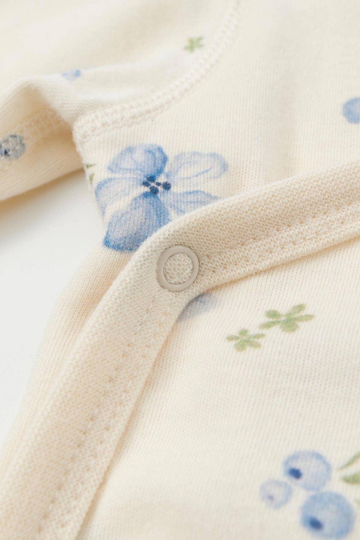 Close-up of a baby outfit with floral patterns on a white background