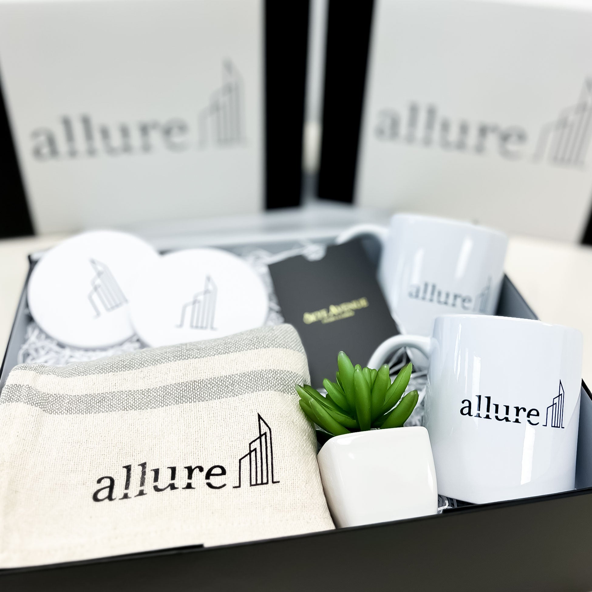 Collection of 'allure' branded items including mugs, a plant, and a box.