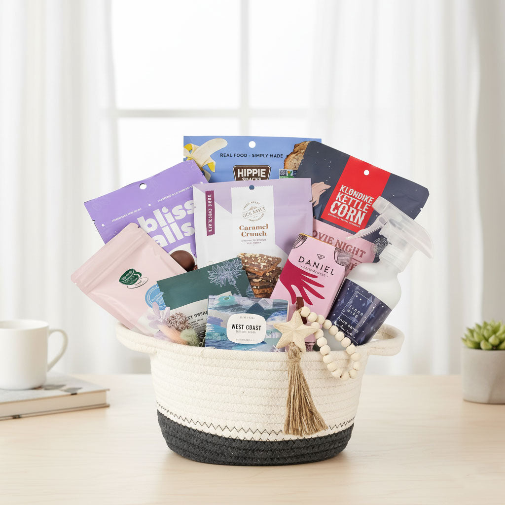 Basket filled with tea, snacks, bath salt, soap and a room spray bottle