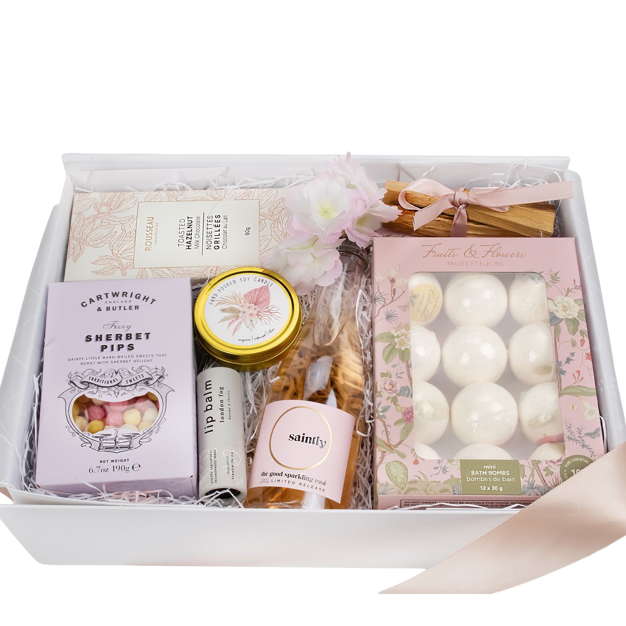 An overhead view of the Blooms and Bubbly spring gift box, featuring a curated arrangement of bath bombs, English candies, and a bubbly gift set, making it an ideal luxury self-care gift and Mother’s Day gift basket.
