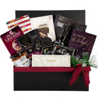 Gourmet gift basket with various items including wine, snacks, and a book inside a black box.