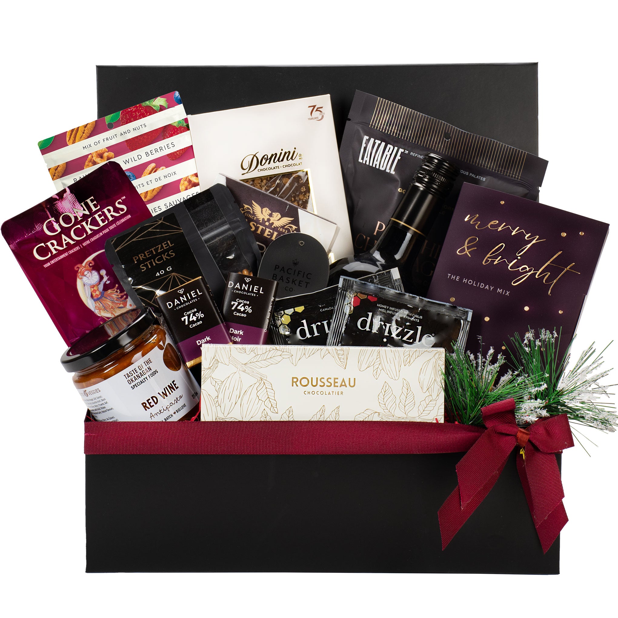Gourmet gift basket with various items including wine, snacks, and a book inside a black box.