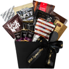 Gourmet gift basket with various snacks and a black box labeled 'With Sympathy' on a white background.