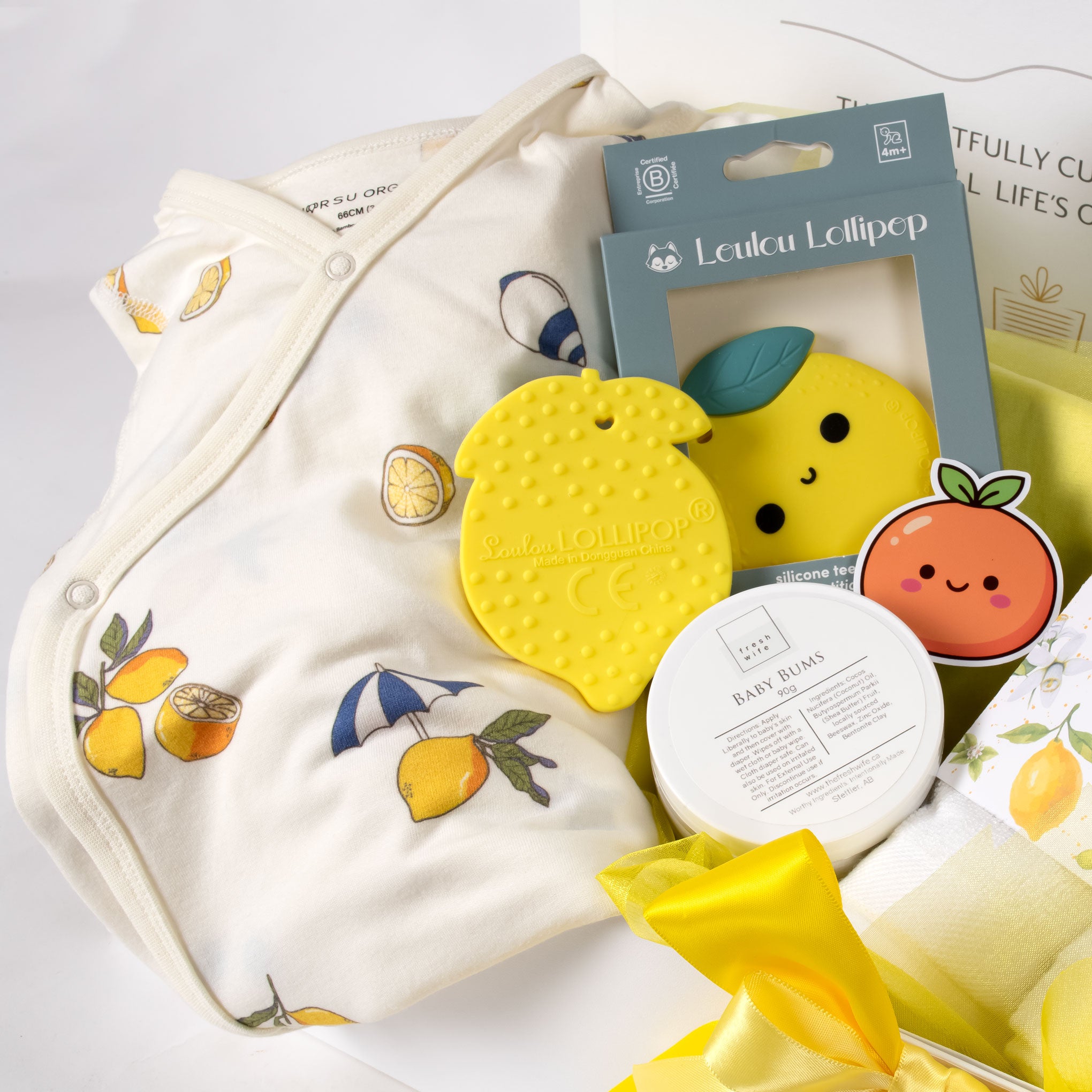 Gender-neutral baby gift basket featuring vibrant organic lemon-print kimono, a yellow lemon teether, and baby bum diaper cream. A premium baby shower gift for Vancouver delivery. 