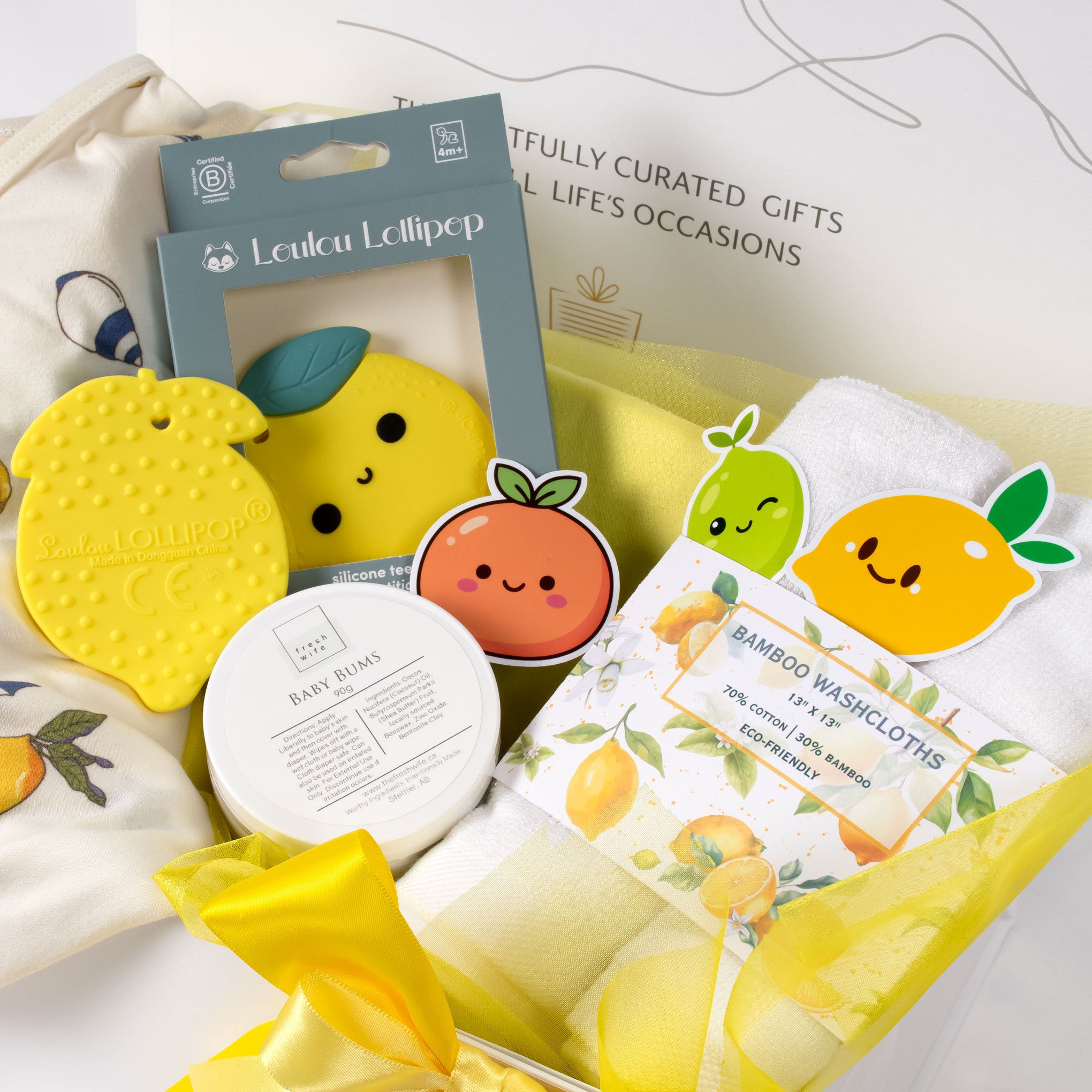 View of the Main Squeeze baby box showcasing the lemon-patterned outfit and milestone stickers—perfect for local Vancouver gift delivery.