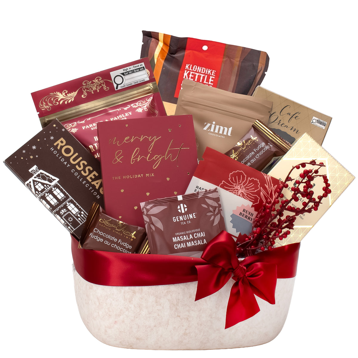 A festive holiday gift basket filled with assorted packaged snacks and treats, tied with a wide red ribbon and bow. Visible items include a red card reading 'merry & bright,' a bag labeled 'Kloninke Kettle,' a brown package labeled 'Rousseau,' and other holiday-themed packaged goods on a plain white background.