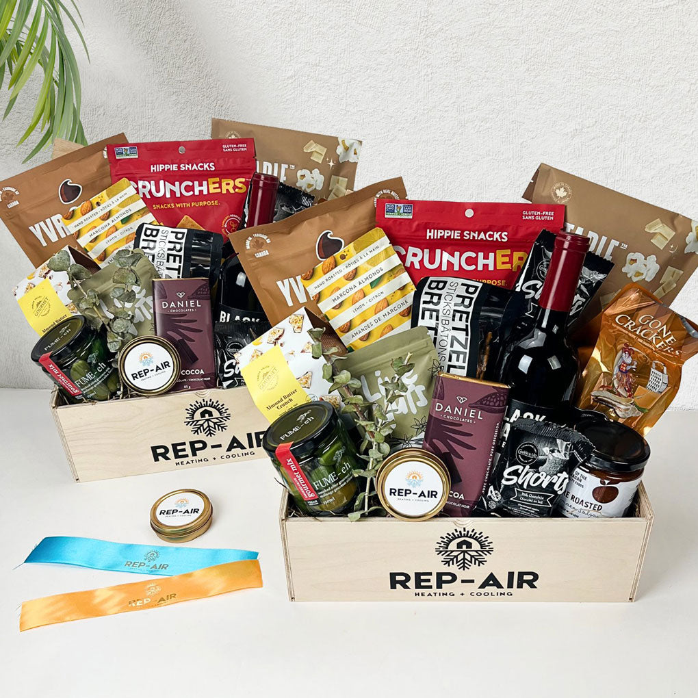 Gourmet gift basket with various snacks and drinks on a white surface, featuring the brand 'REP-AIR'.