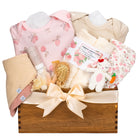 Handcrafted wooden baby gift basket called Sweet Orchard featuring apple and peach print onesies, bamboo washcloths, and a crochet bunny on a white background.