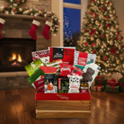 Gift basket with holiday-themed products in front of a Christmas tree and fireplace.